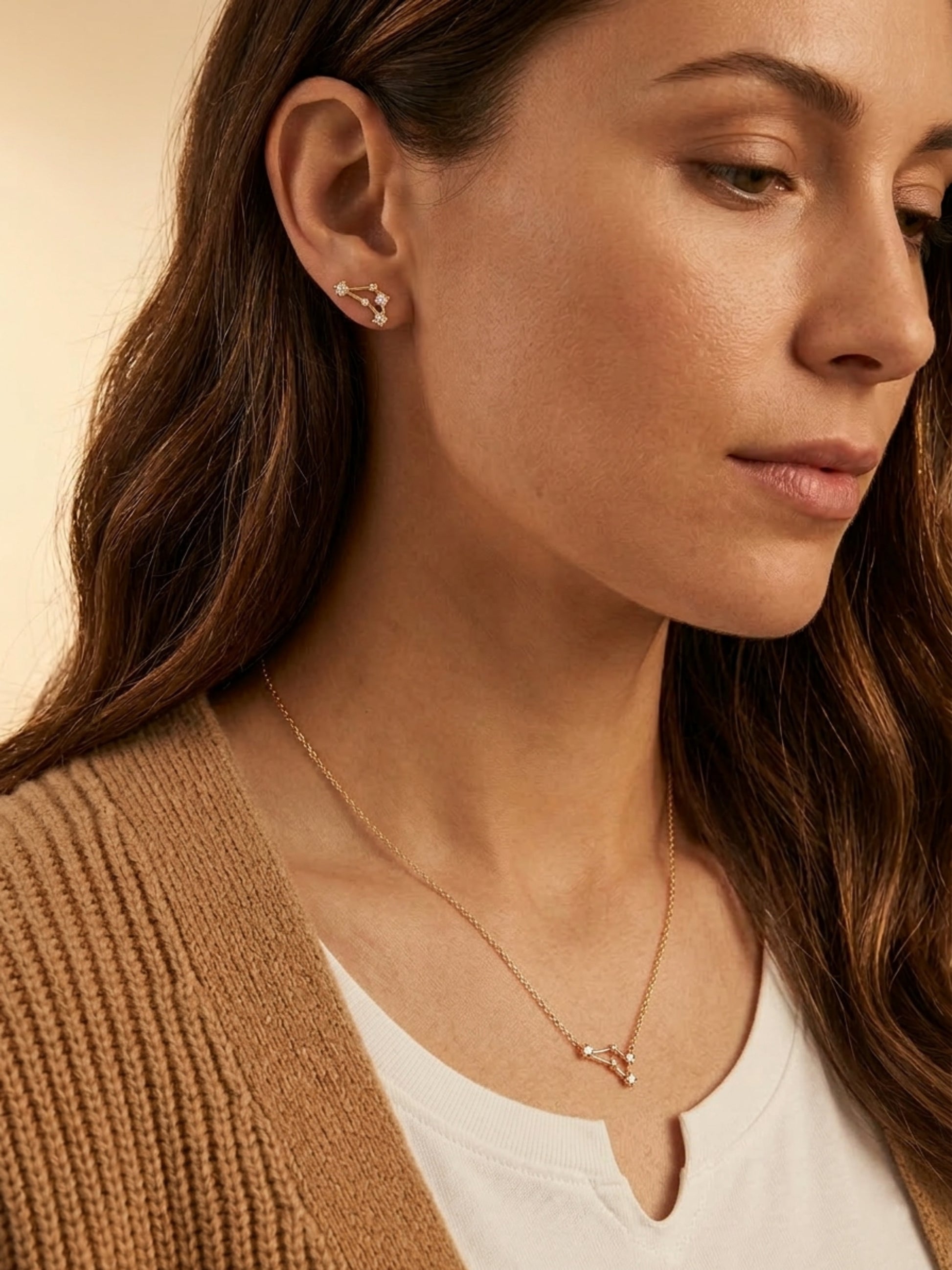 Close-up of a woman wearing a capricorn necklace and capricorn earring, showcasing the luxury aesthetic and pendant scale.