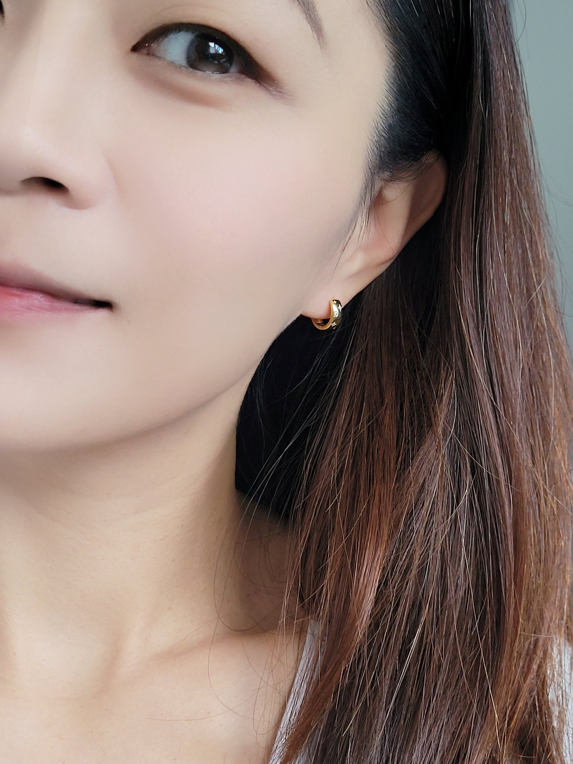 Dainty gold hoop earrings featuring a celestial star motif, crafted in 925 sterling silver and 18K gold vermeil.