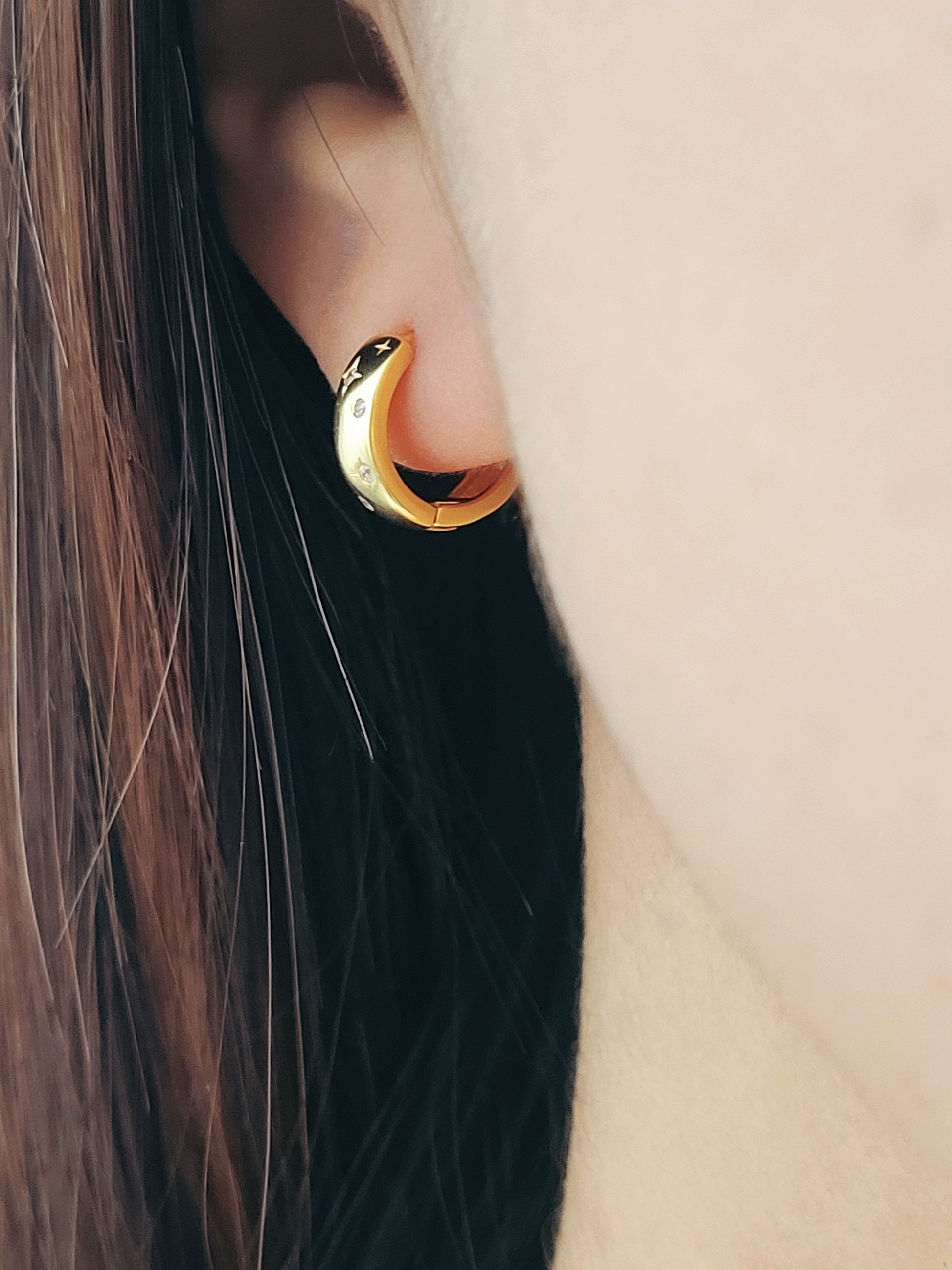 Minimalist celestial themed hoop earrings in 18K gold vermeil, designed with shimmering star details.