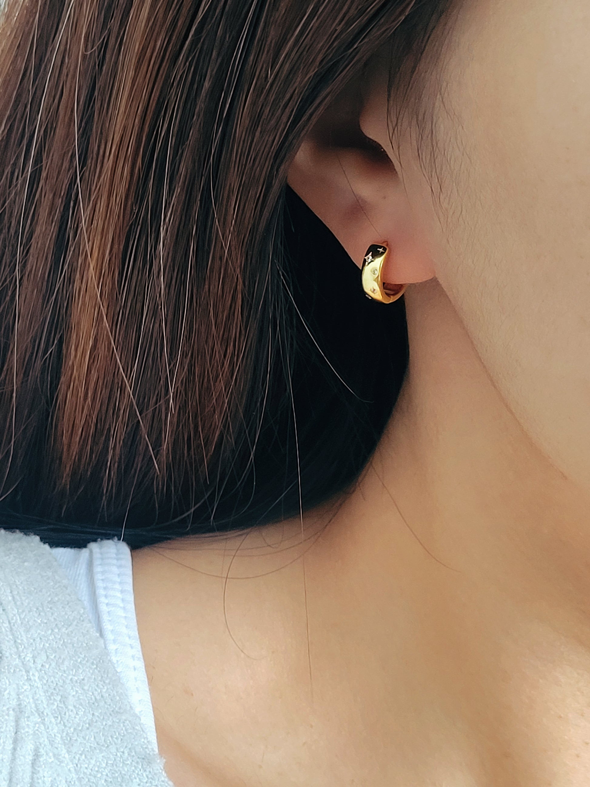 Dainty gold hoop earrings featuring a celestial star motif, crafted in 925 sterling silver and 18K gold vermeil.