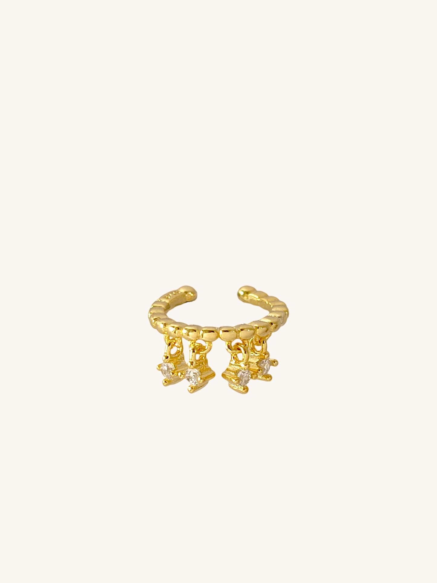 A stunning gold-plated cuff earring adorned with three tiny diamonds, perfect for adding a touch of glam to any outfit.