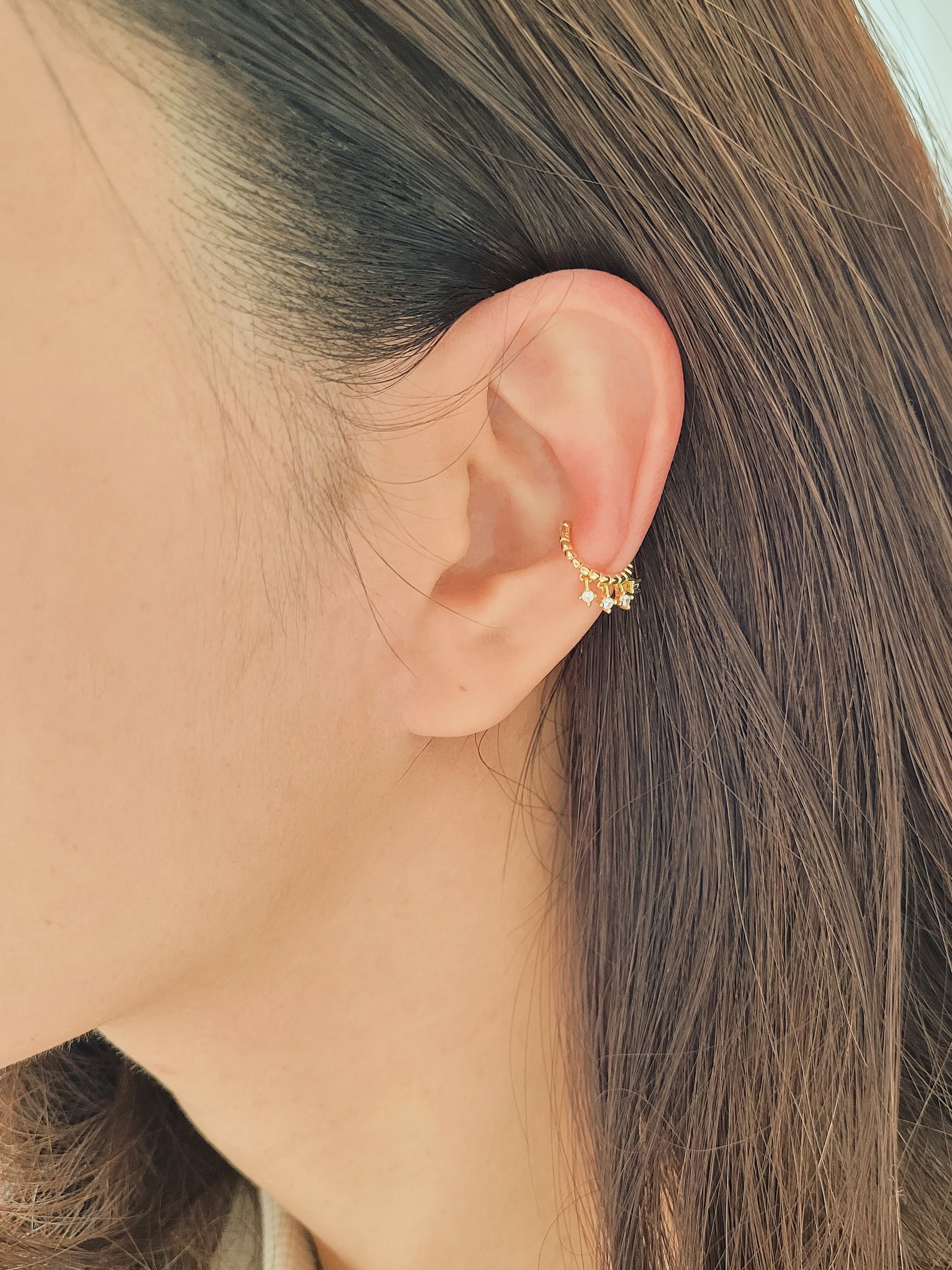 A chic gold-plated ear cuff with three delicate diamonds, blending luxury and style effortlessly.