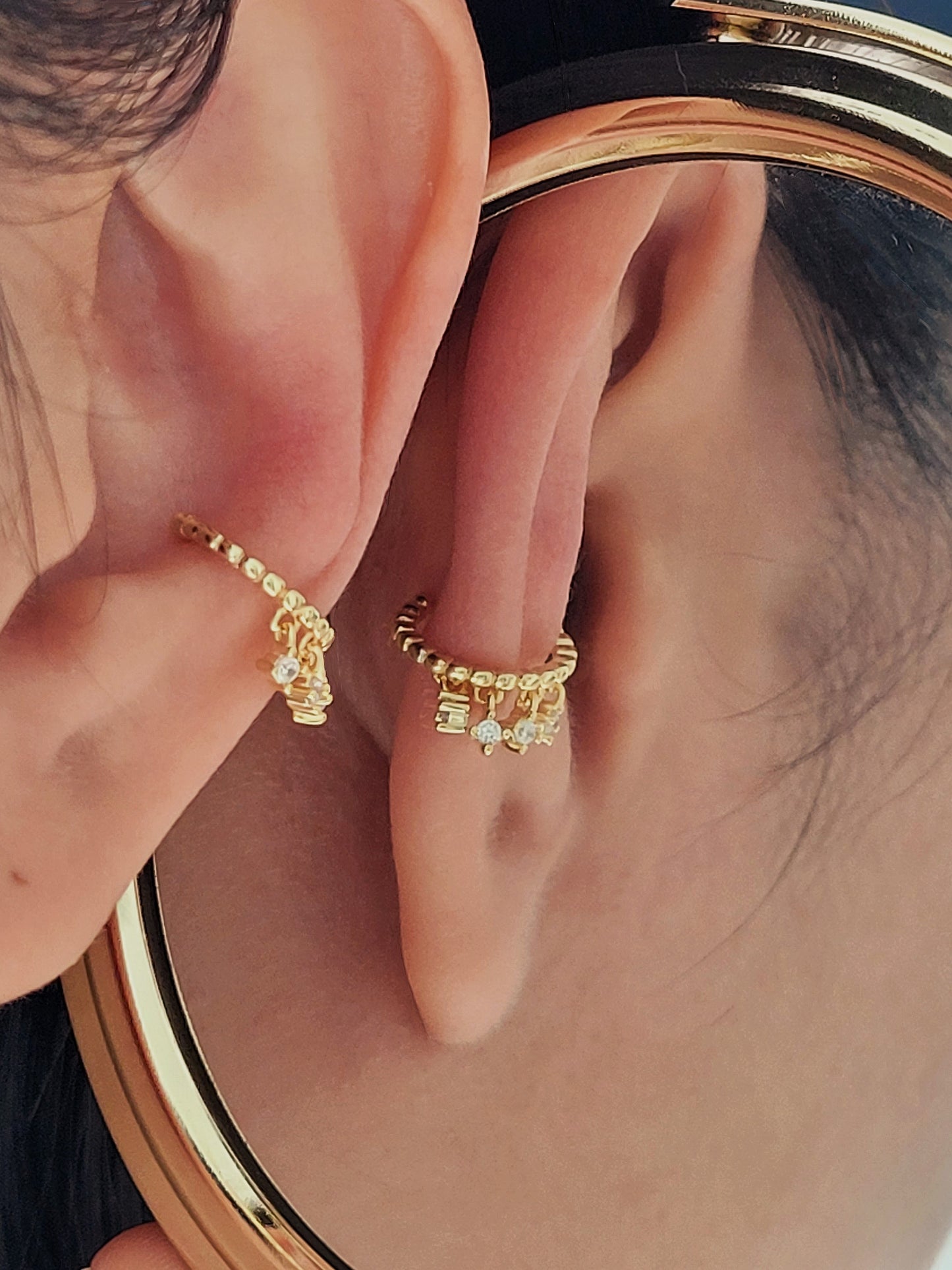 A stunning gold-plated cuff earring adorned with three tiny diamonds, perfect for adding a touch of glam to any outfit.