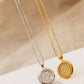Two necklaces, one gold and one silver, with circular pendants on a beige fabric background.