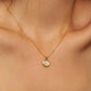 Elegant woman wearing a dainty 18K gold plated sterling silver circle pendant necklace with shimmering cubic zirconia accents, perfect for everyday wear and special occasions.