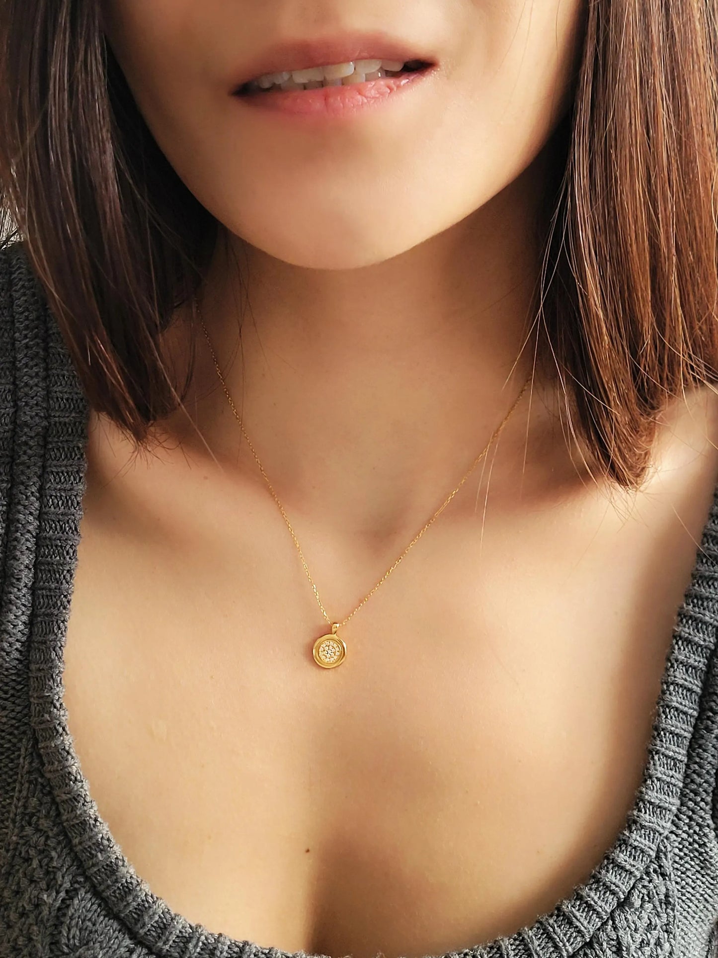 Elegant woman wearing a dainty 18K gold plated sterling silver circle pendant necklace with shimmering cubic zirconia accents, perfect for everyday wear and special occasions.