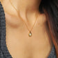 Elegant woman wearing a dainty 18K gold plated sterling silver circle pendant necklace with shimmering cubic zirconia accents, perfect for everyday wear and special occasions.