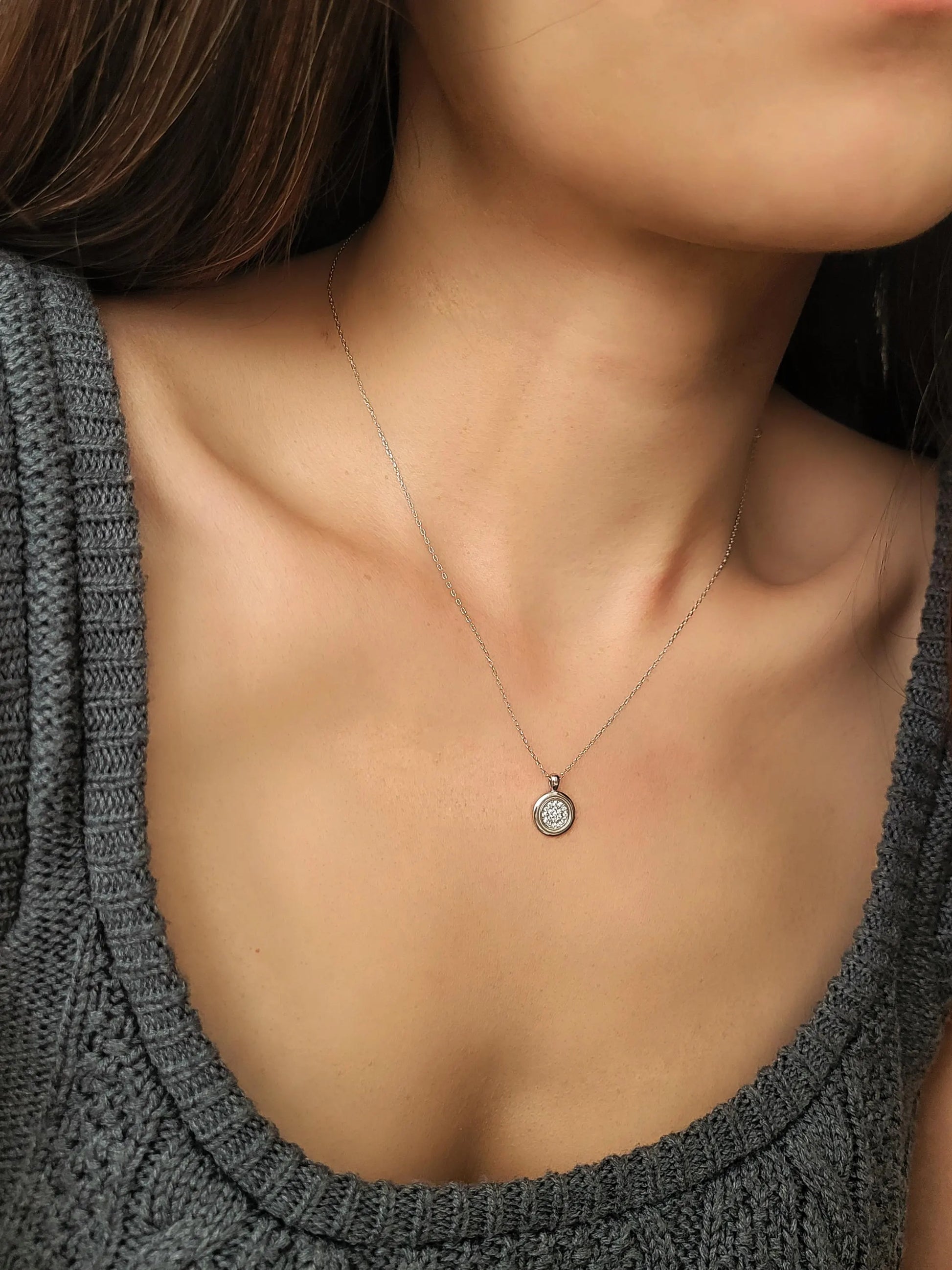 Elegant woman wearing a dainty sterling silver circle pendant necklace with shimmering cubic zirconia accents, perfect for everyday wear and special occasions.