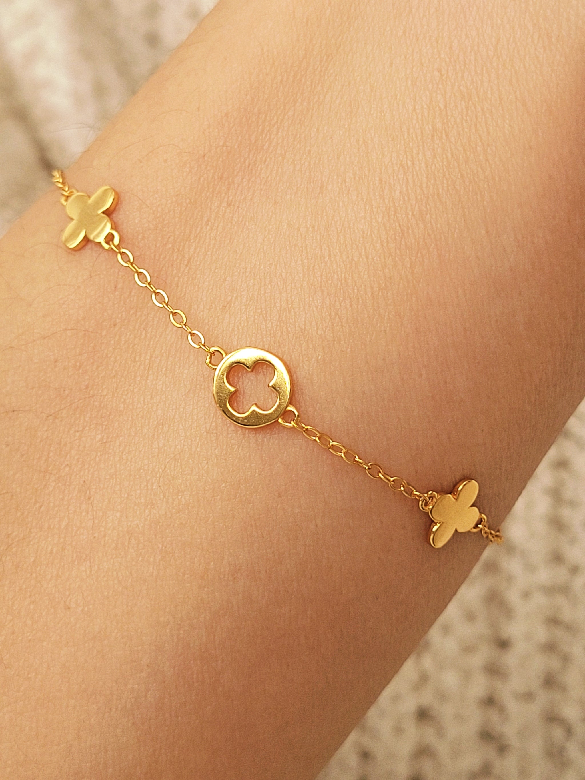 A dainty gold bracelet featuring four leaf clover motif, crafted in gold plated sterling silver.