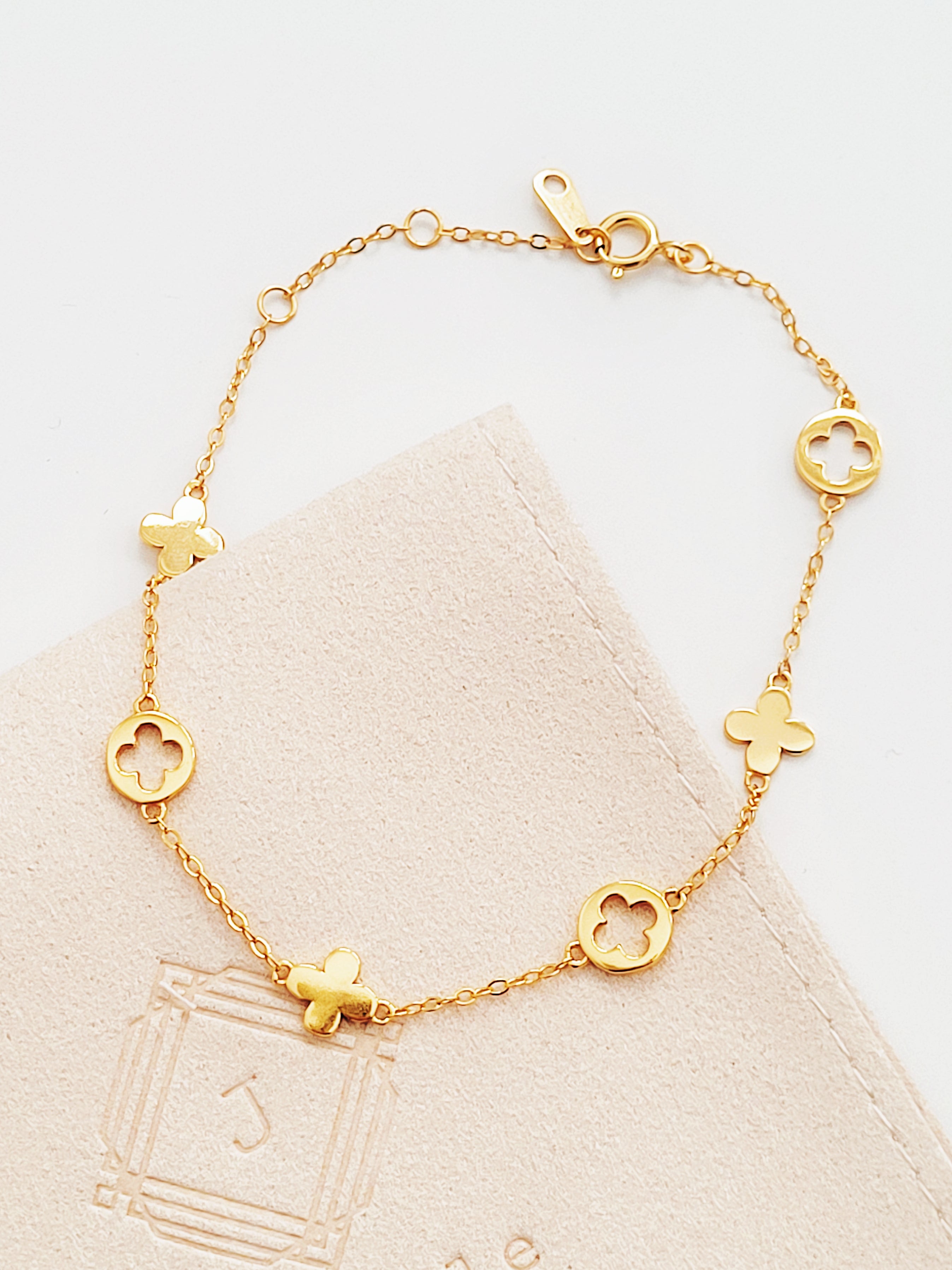 A dainty gold bracelet featuring lucky clover motif charms, crafted in gold plated sterling silver.