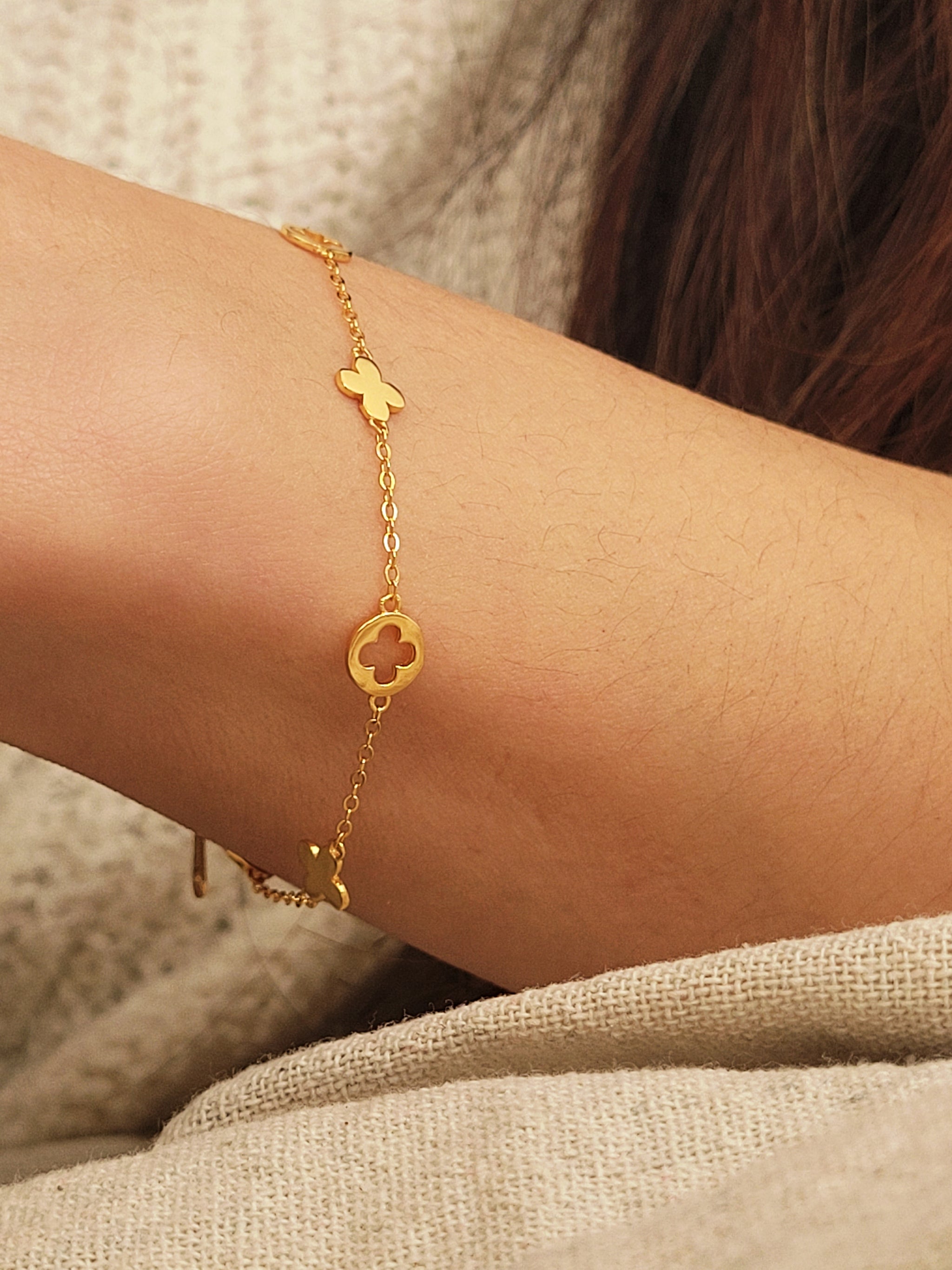A dainty gold bracelet featuring clover charms, crafted in gold plated sterling silver.