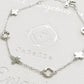 A dainty sterling silver bracelet with van cleef clover charms.