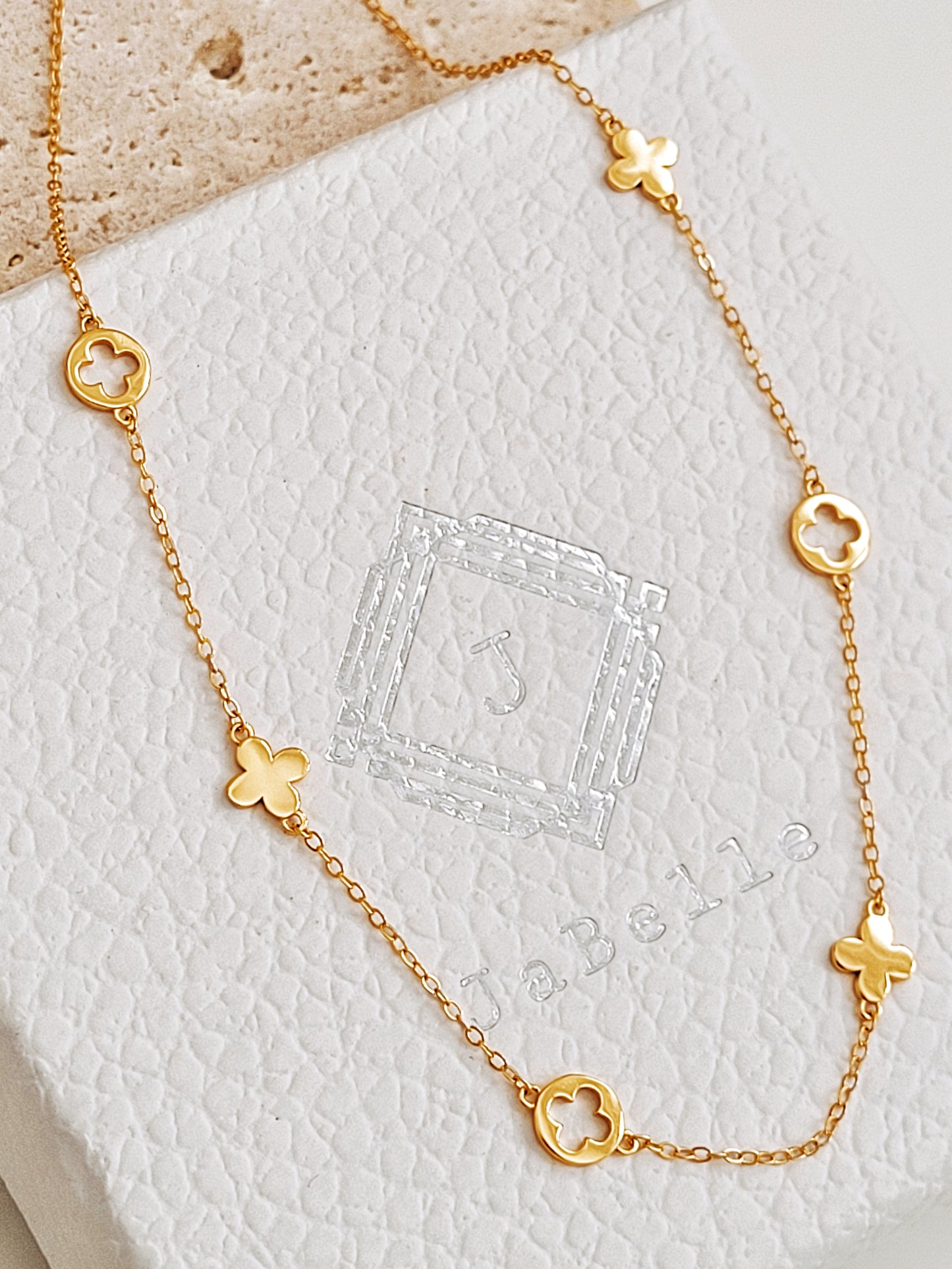 Dainty gold plated clover necklace displayed on JaBelle Jewellery box.