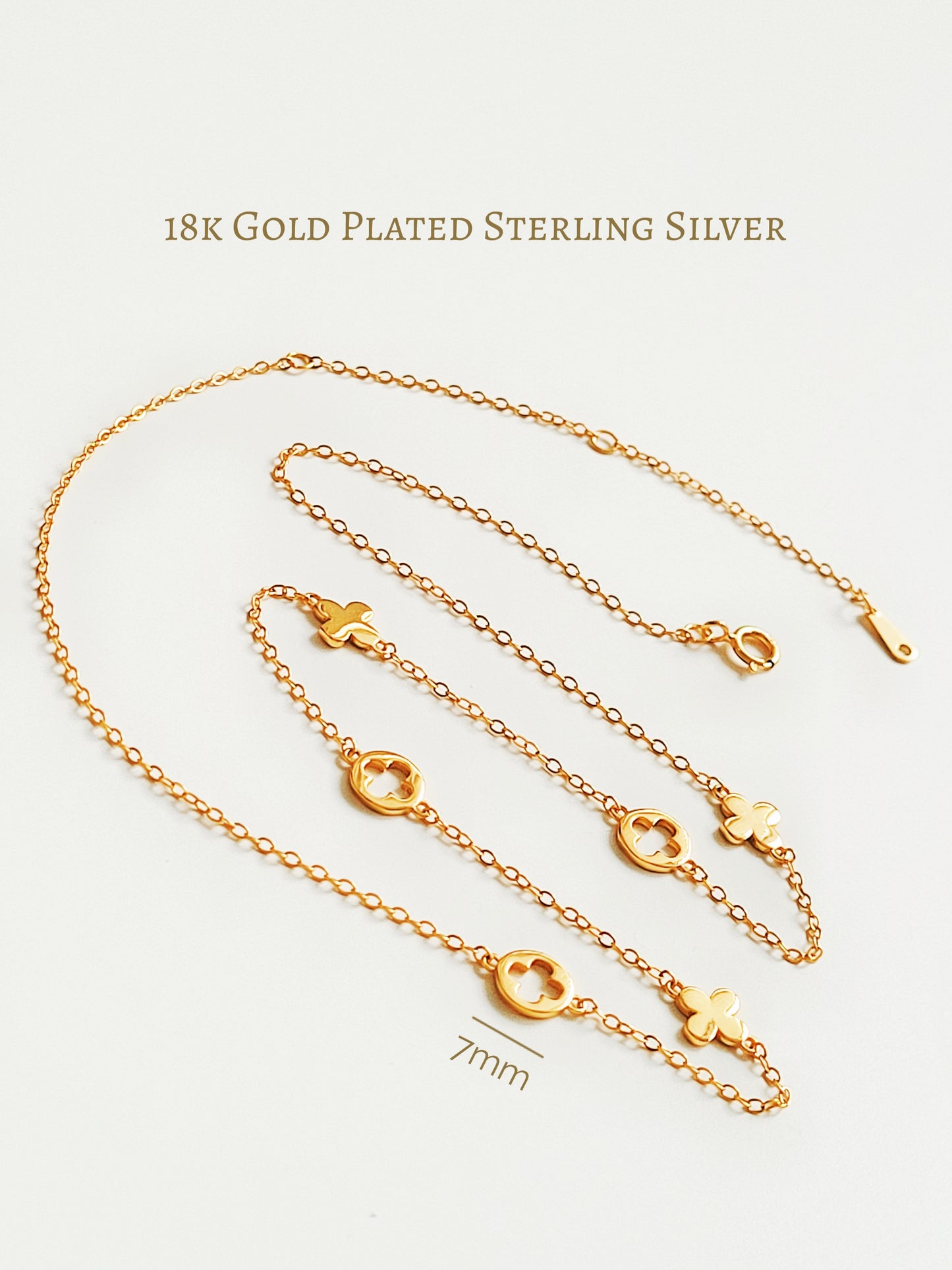 Gold plated sterling silver chain necklace with clover motif links on a white background