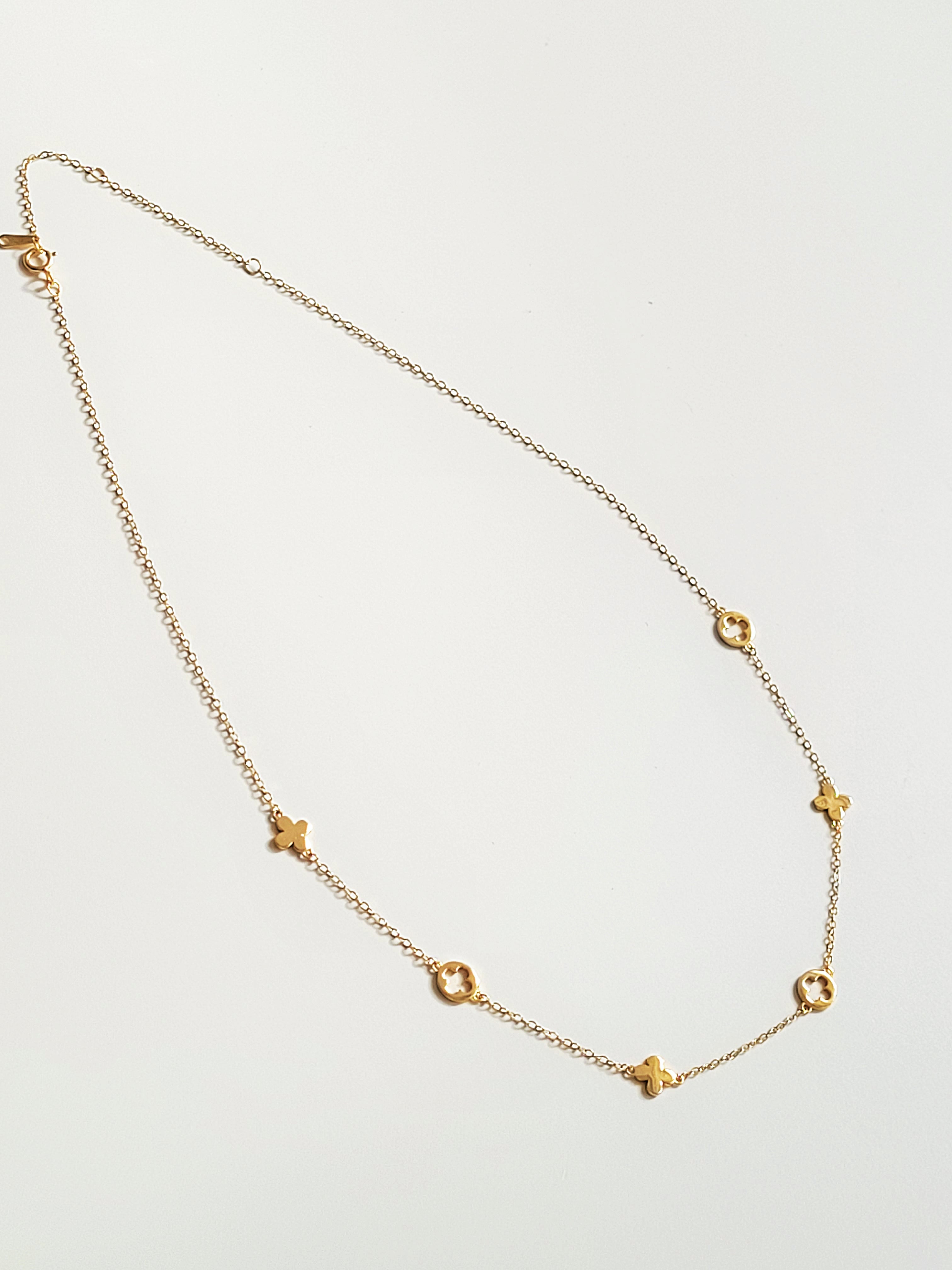 Gold necklace with star-shaped pendants on a light gray background