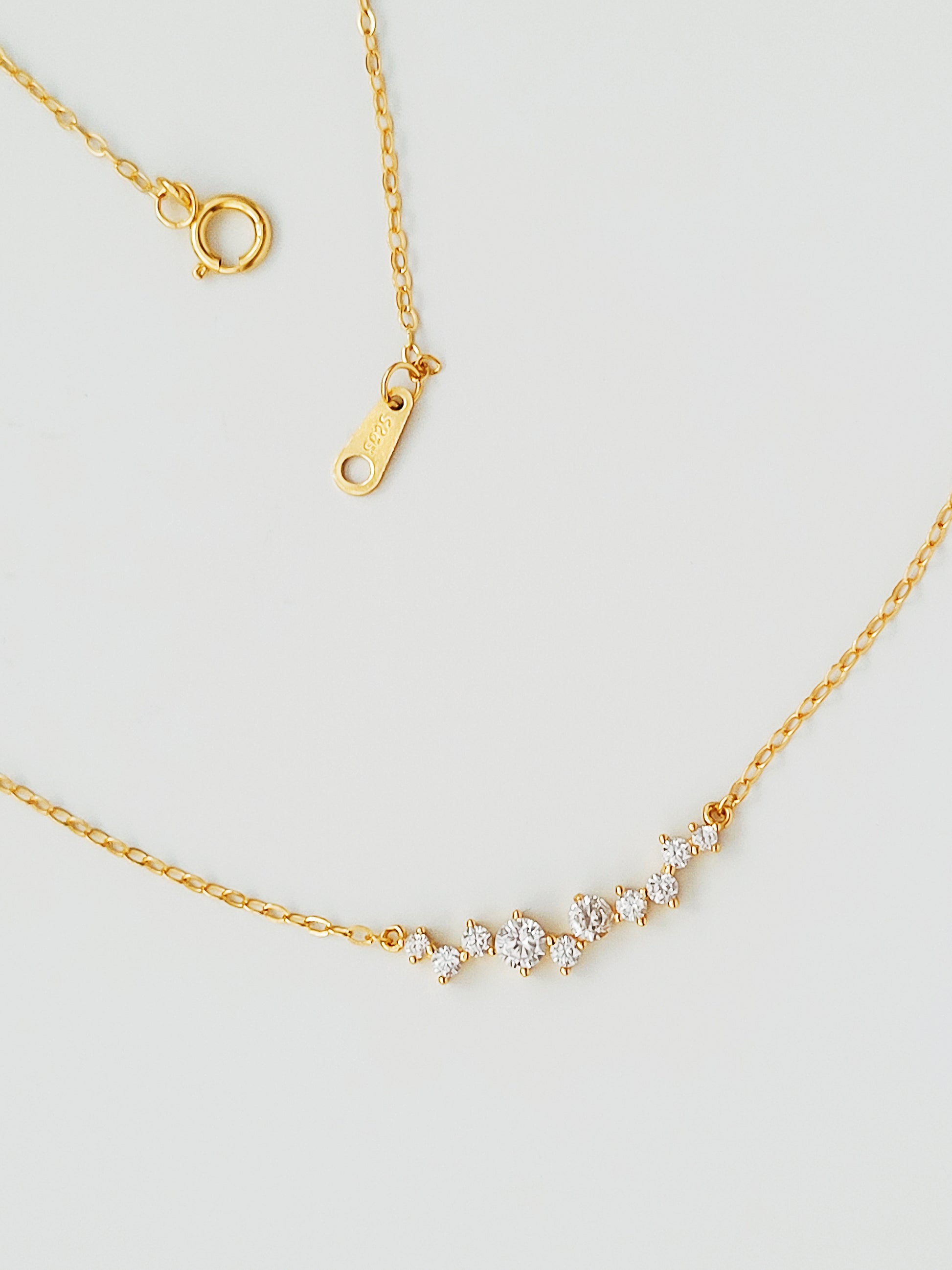 Minimalist gold necklace with sparkling stones, ideal for everyday wear or layering.