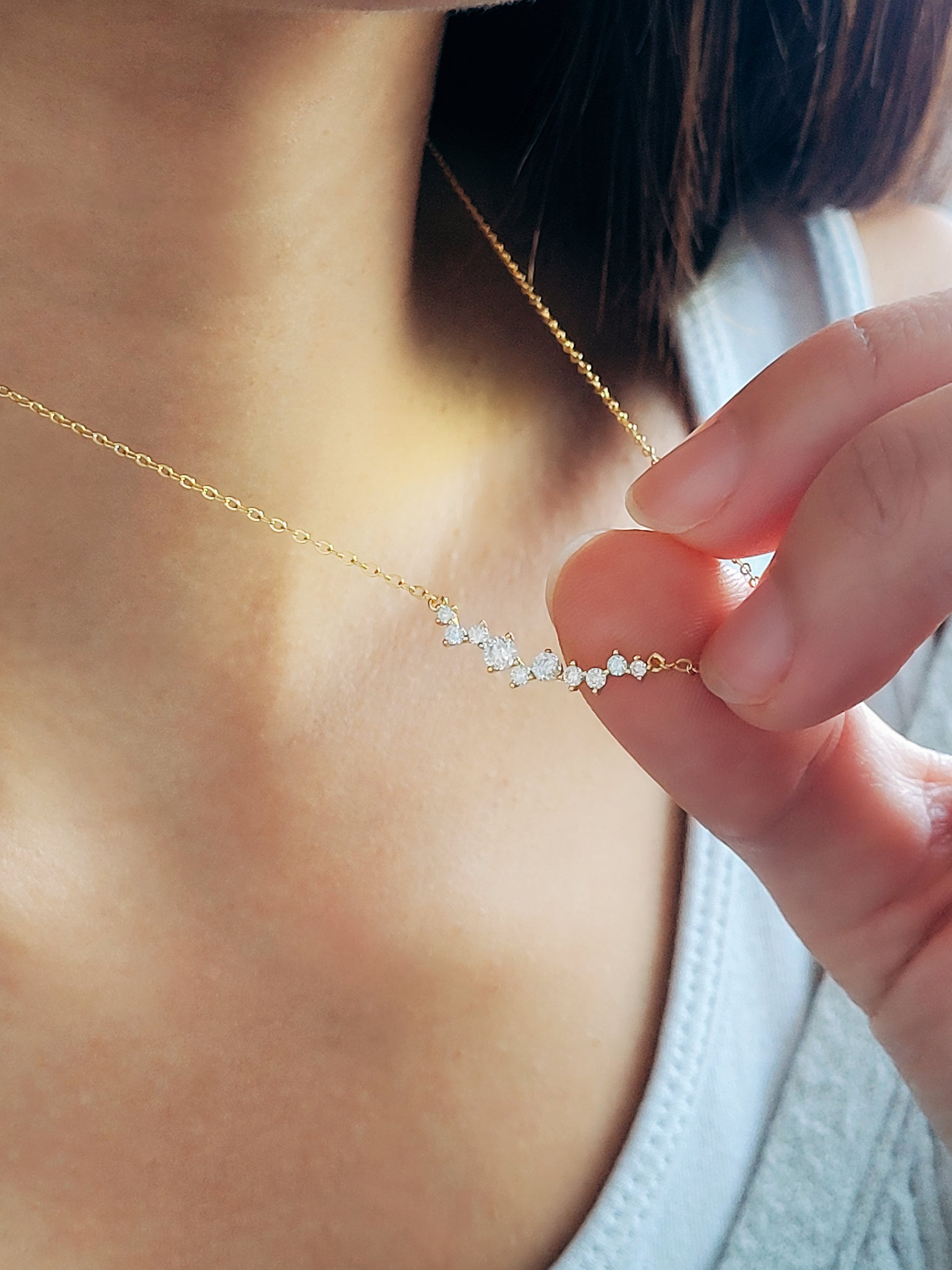 Elegant curved pendant necklace displayed on a model, adding a subtle sparkle.