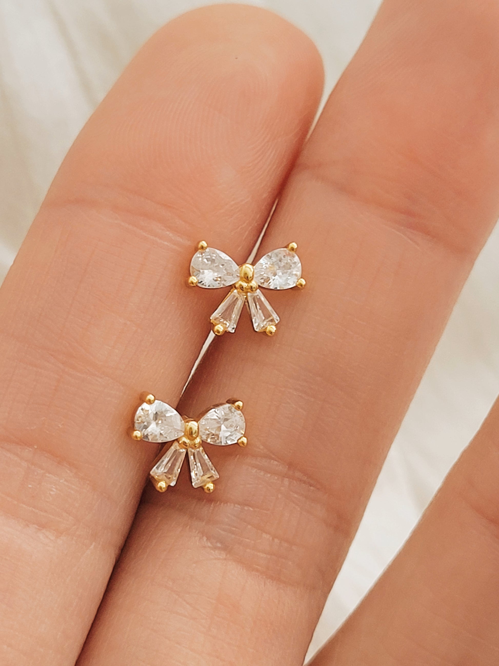 Elegant bow-shaped stud earrings in 18K gold plating, ideal for everyday wear and gifting