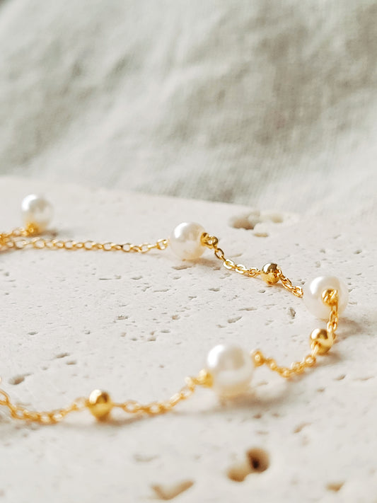 A delicate gold-plated sterling silver bracelet featuring pearls and an adjustable bead chain, ideal for weddings or gifting to loved ones.