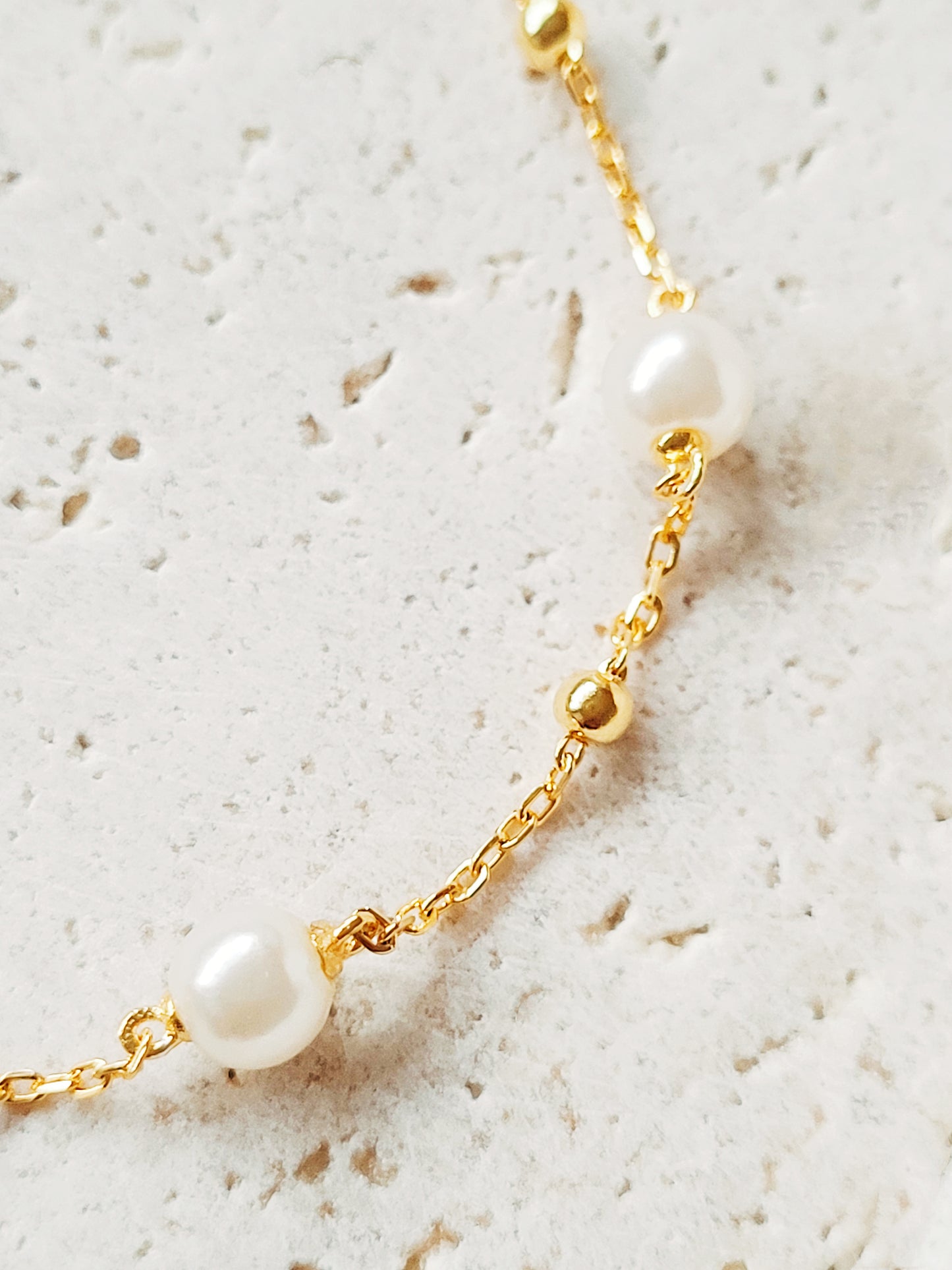 A delicate gold-plated sterling silver bracelet featuring pearls and an adjustable bead chain, ideal for weddings or gifting to loved ones.