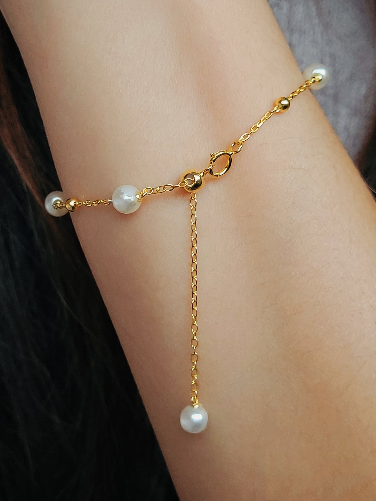 A delicate gold-plated sterling silver bracelet featuring pearls and an adjustable bead chain, ideal for weddings or gifting to loved ones.