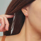 Close-up of a woman&#39;s ear wearing an 18K gold-plated cubic zirconia climber earring, highlighting the elegant and minimalist design.