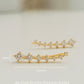 A pair of gold-plated sterling silver climber earrings adorned with cubic zirconia stones, displayed on a clean white surface.