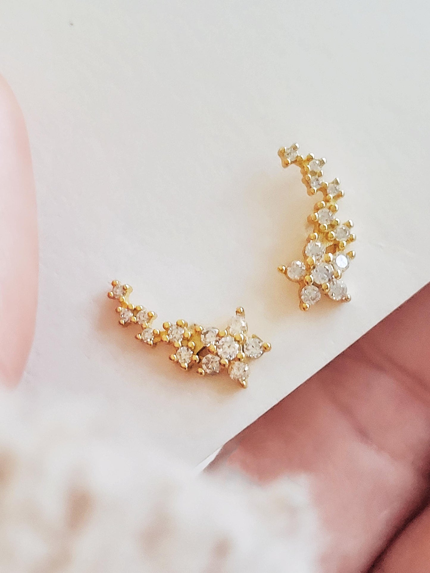 Close-up of dainty gold flower climber earrings with cubic zirconia stones on a white background, crafted in 18k gold plated sterling silver.