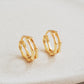 Close-up image of double hoop huggie earrings in octagon shape, featuring a minimalist gold geometric design, worn on an ear. Perfect for everyday wear.