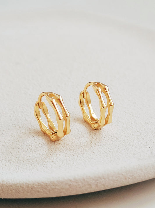 Close-up image of double hoop huggie earrings in octagon shape, featuring a minimalist gold geometric design, worn on an ear. Perfect for everyday wear.