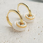 Elegant yellow gold plated Enamel disc and white donut drop hoop earrings featuring a delicate flower design, perfect for adding a touch of charm.