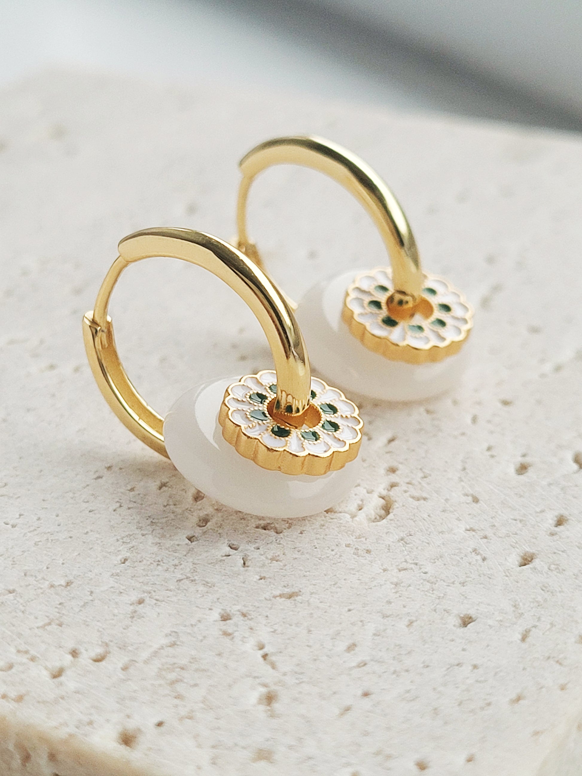 Elegant yellow gold plated Enamel disc and white donut drop hoop earrings featuring a delicate flower design, perfect for adding a touch of charm.