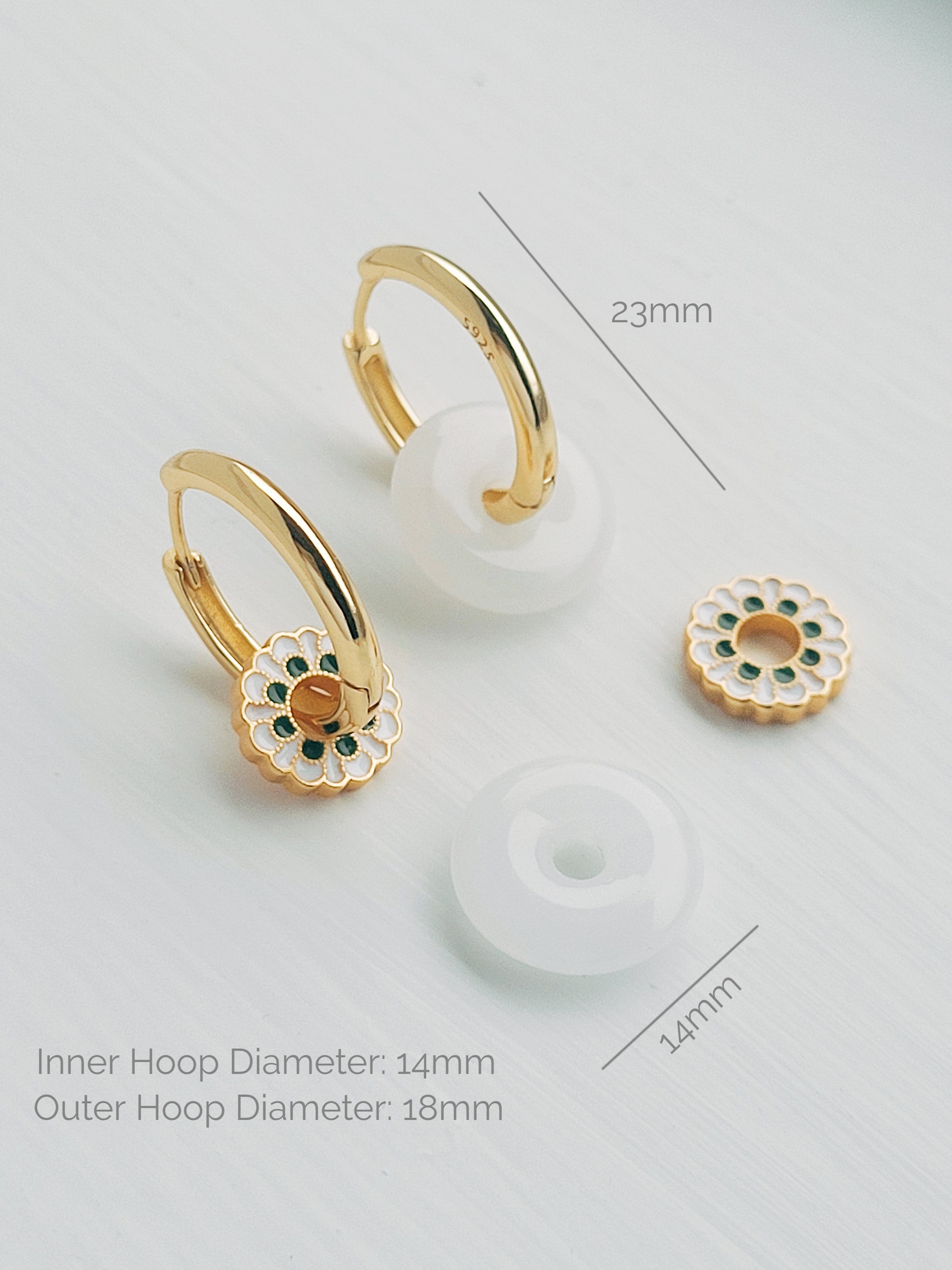 Stunning white drop hoop earrings featuring a floral enamel motif, capturing the essence of intricate ceramic tile artistry. A perfect twist of classic and modern designer earrings.