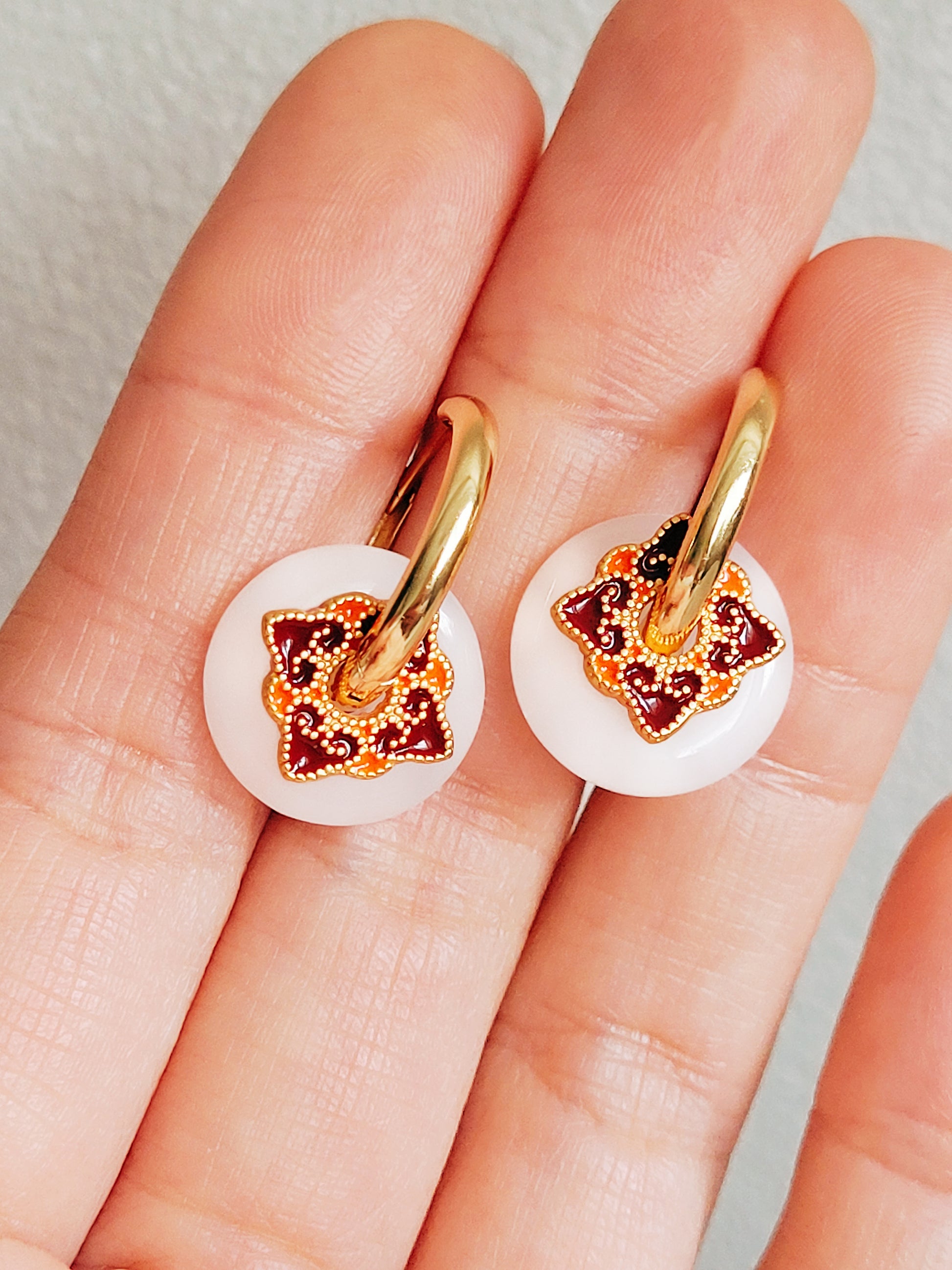Boho-style gold-plated hoop earrings featuring intricate enamel charms, perfect for women’s unique fashion.