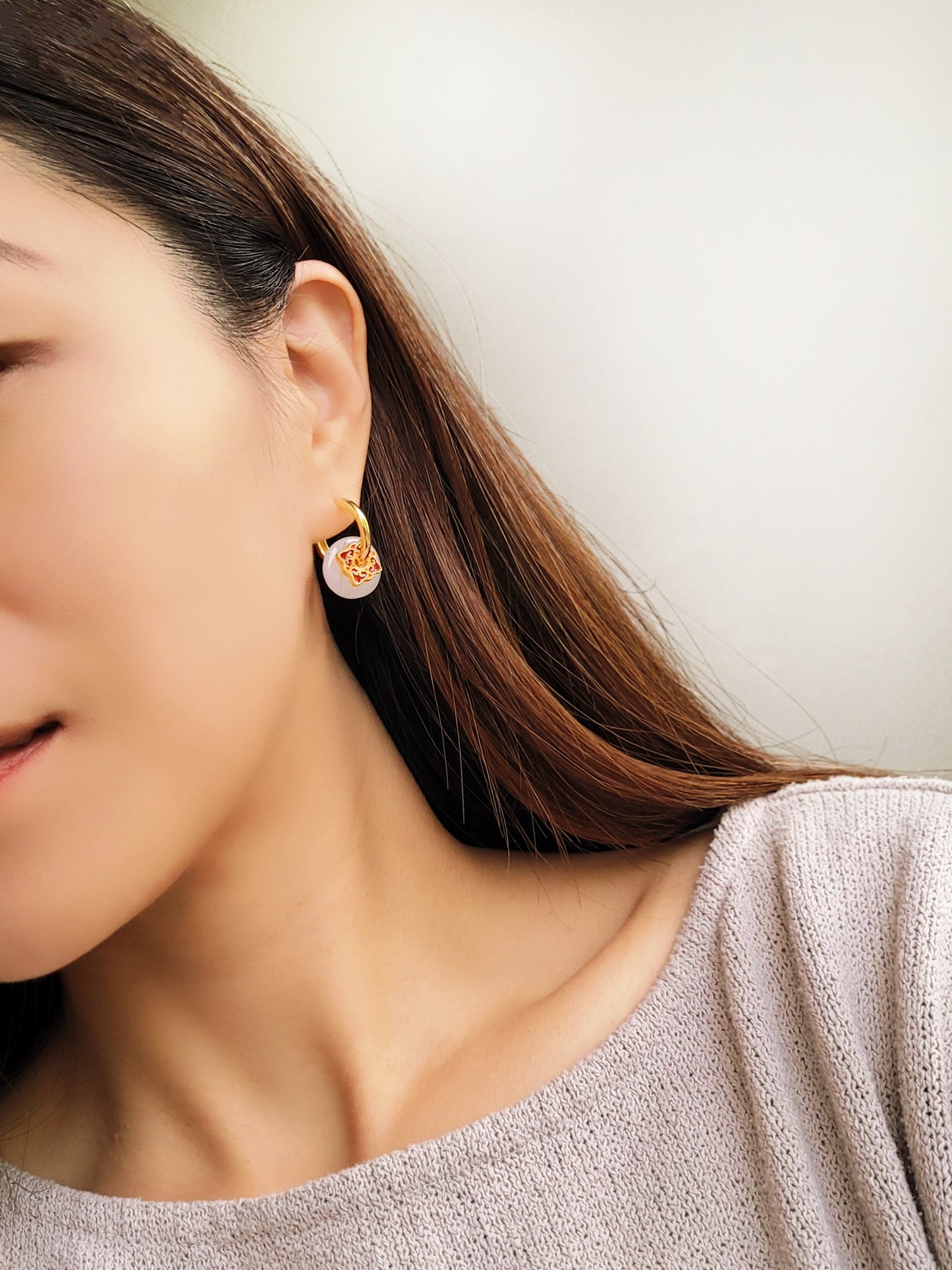 Close up of a woman’s ear wearing a stylish enamel charm earrings with boho flair, inspired by vintage tile designs and crafted for modern wear.