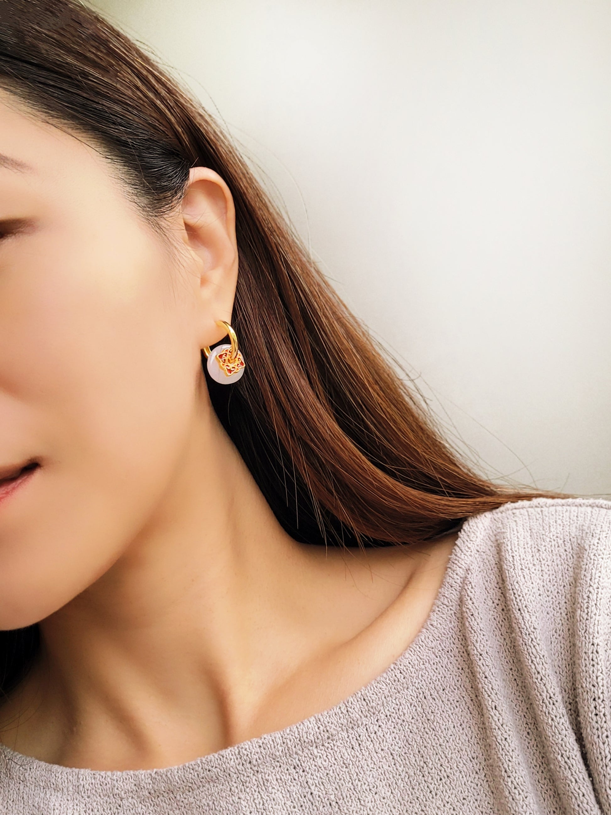Close up of a woman’s ear wearing a stylish enamel charm earrings with boho flair, inspired by vintage tile designs and crafted for modern wear.