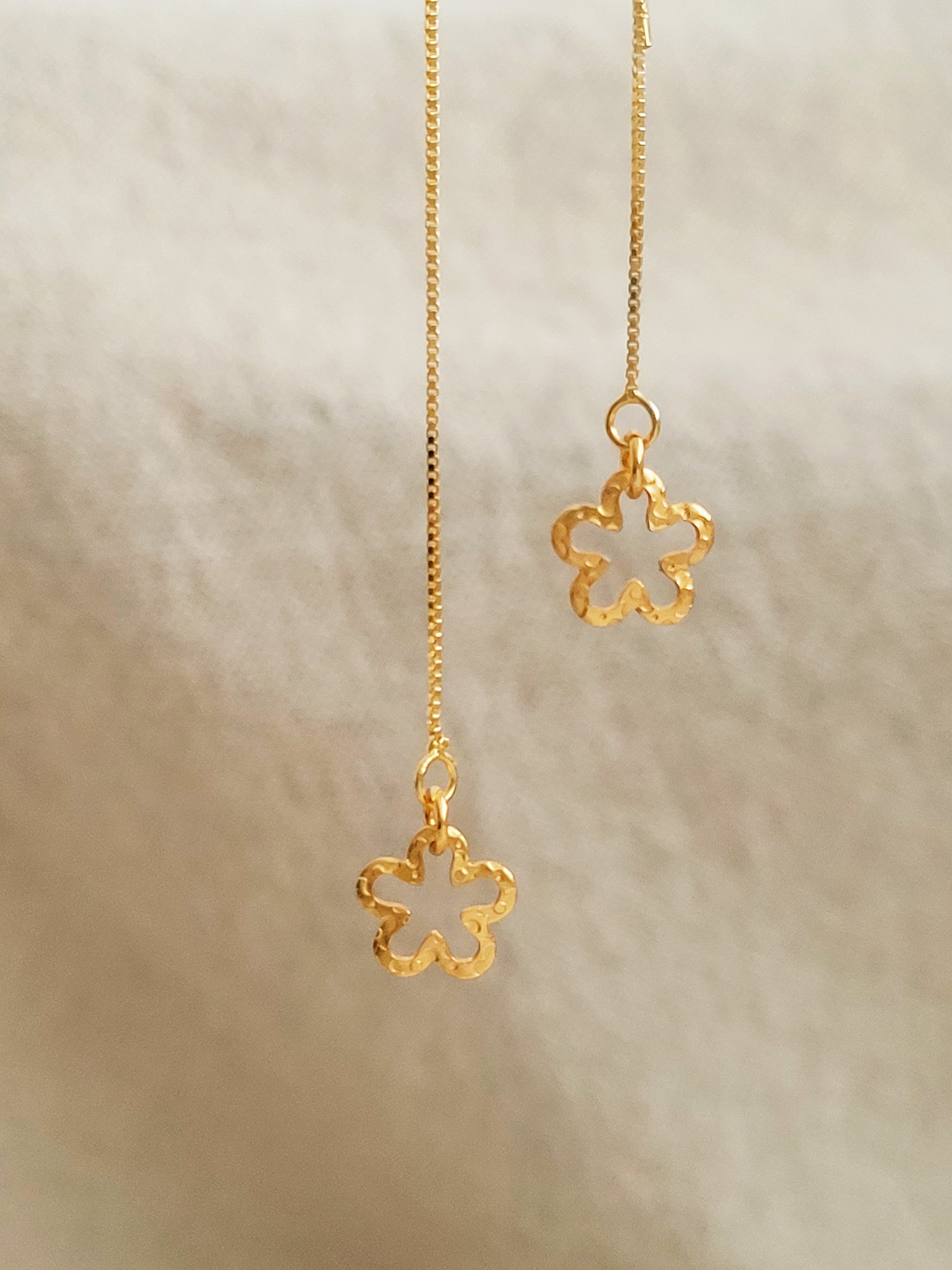 Close up of the flower dangle on the gold threader earrings, crafted in gold plated 925 sterling silver with hammered texture.