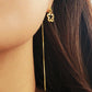 Gold threader pull through earring in gold worn by a woman with long dark hair.