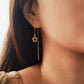 Close-up of a girl wearing a gold flower-shaped threader earring.