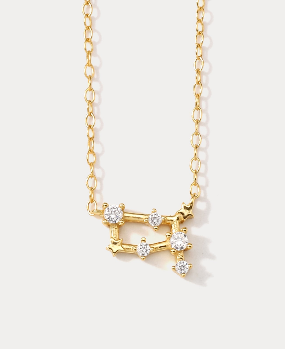 A dainty gold necklace with a pendant featuring a stylized Gemini zodiac constellation sign with sparkling zircons crafted in gold plated sterling silver. Ideal birthday gift for her.