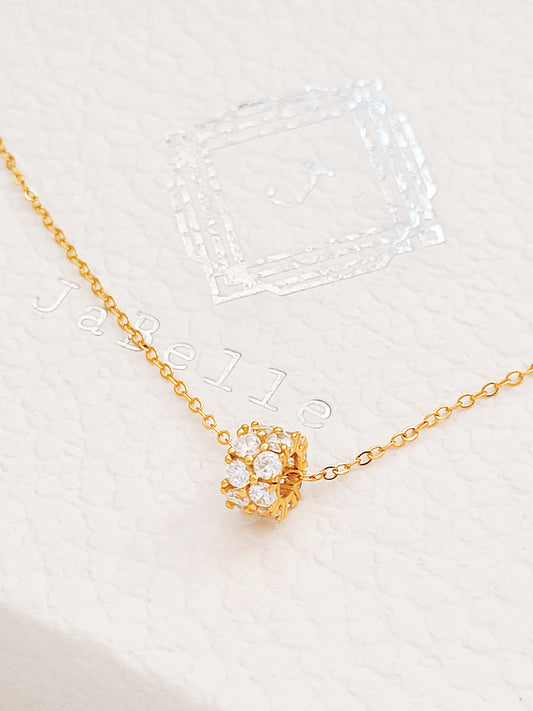 Luxurious close-up of a gold round shaped barrel necklace featuring sparkling pave zircons.