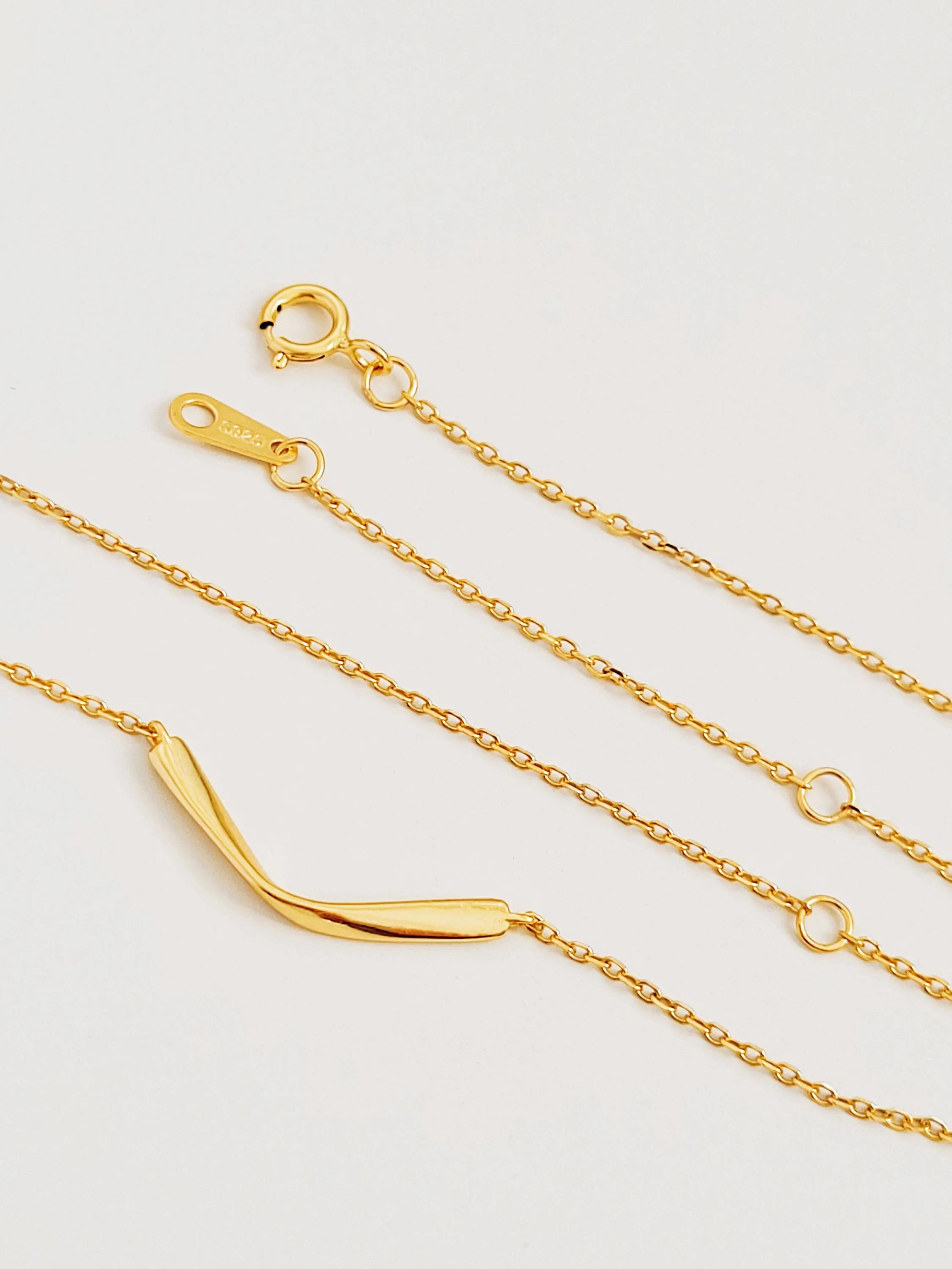 A gold chain necklace with a curved bar pendant crafted in 18k gold plated sterling silver, everyday minimalist style