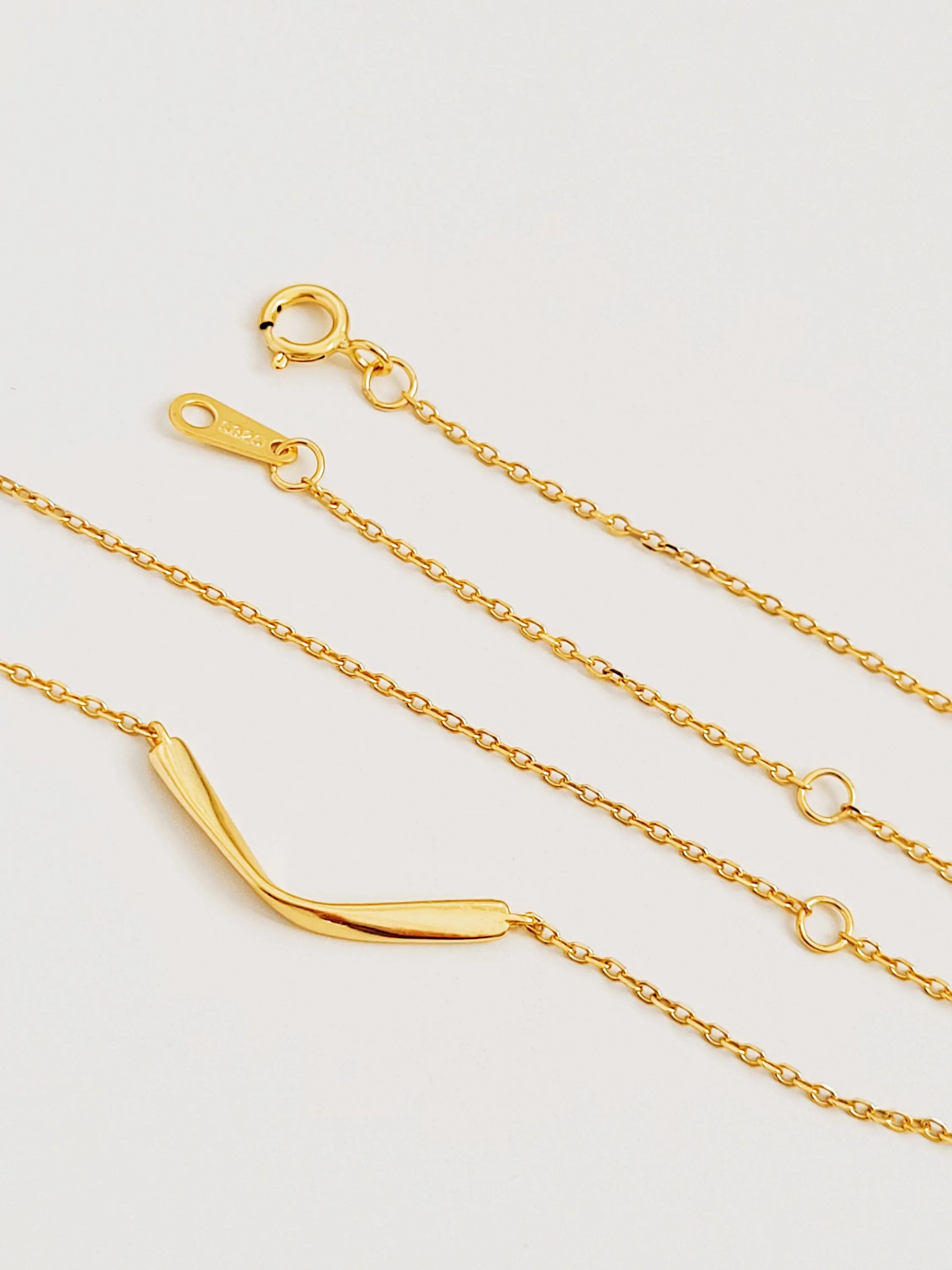 A gold chain necklace with a curved bar pendant crafted in 18k gold plated sterling silver, everyday minimalist style