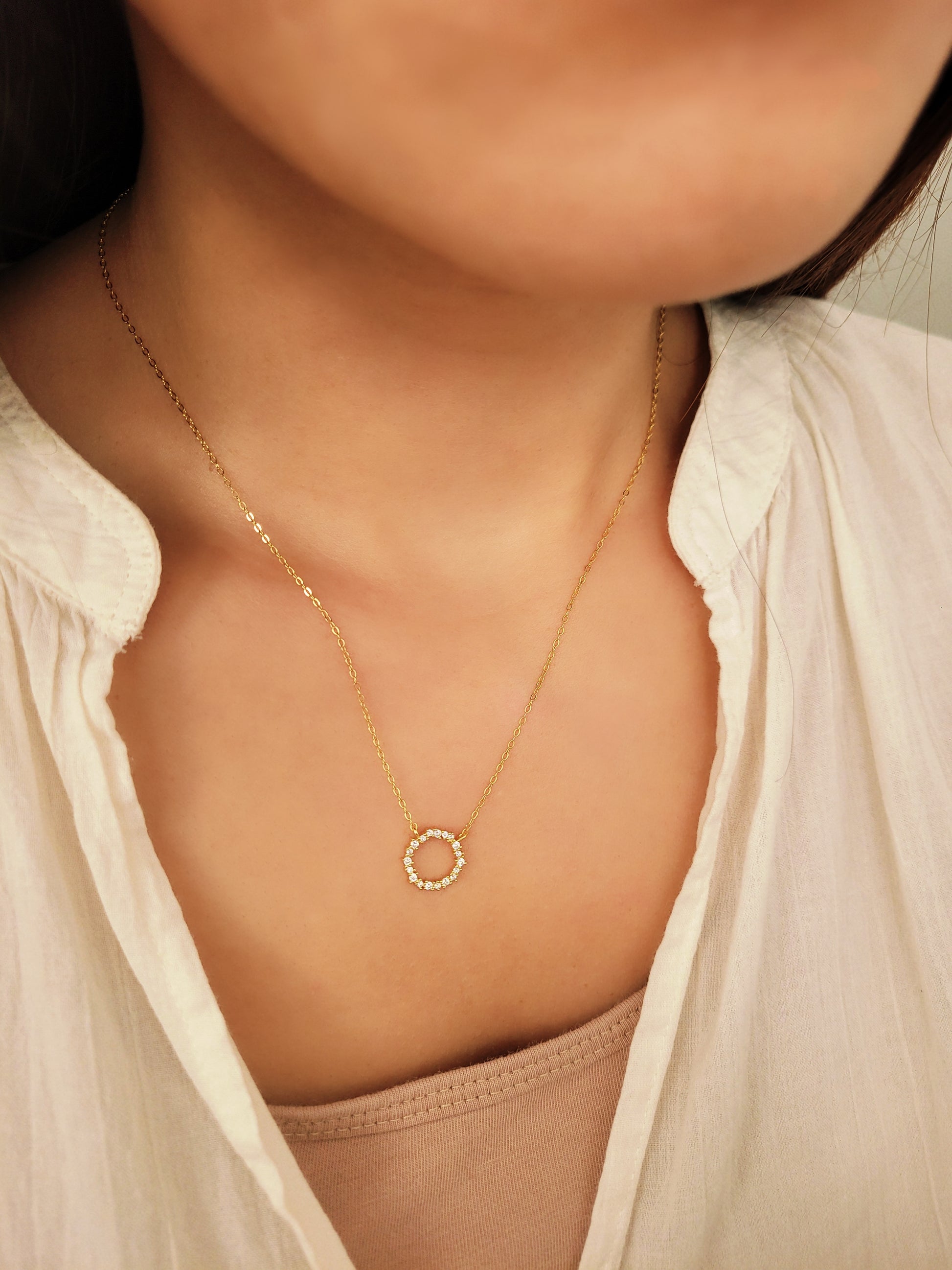 Lifestyle image of the Gold Vermeil Infinity Circle Necklace worn with a casual outfit.