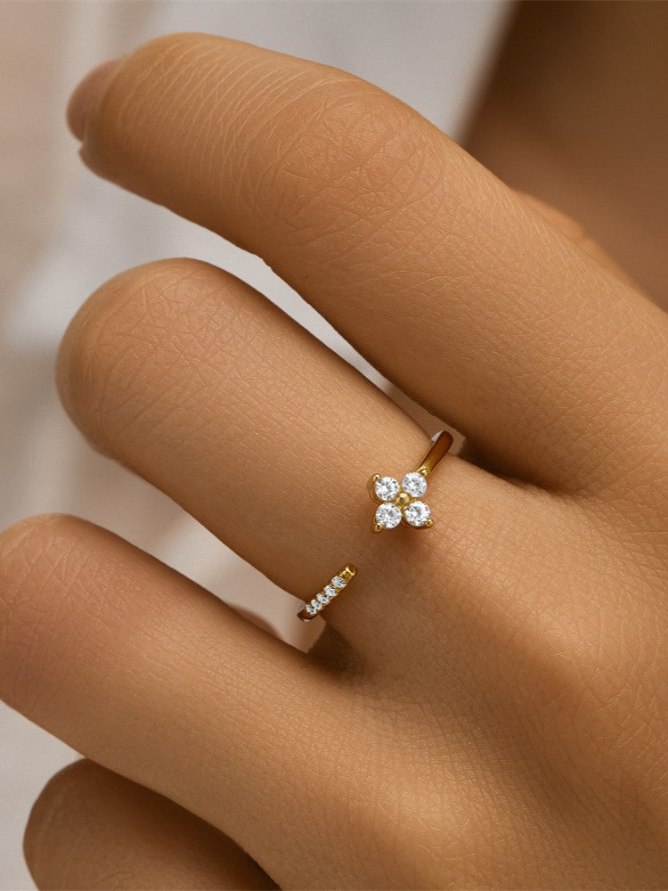 Close-up of a woman's hand showcasing a gold Clover ring featuring four brilliant diamonds.