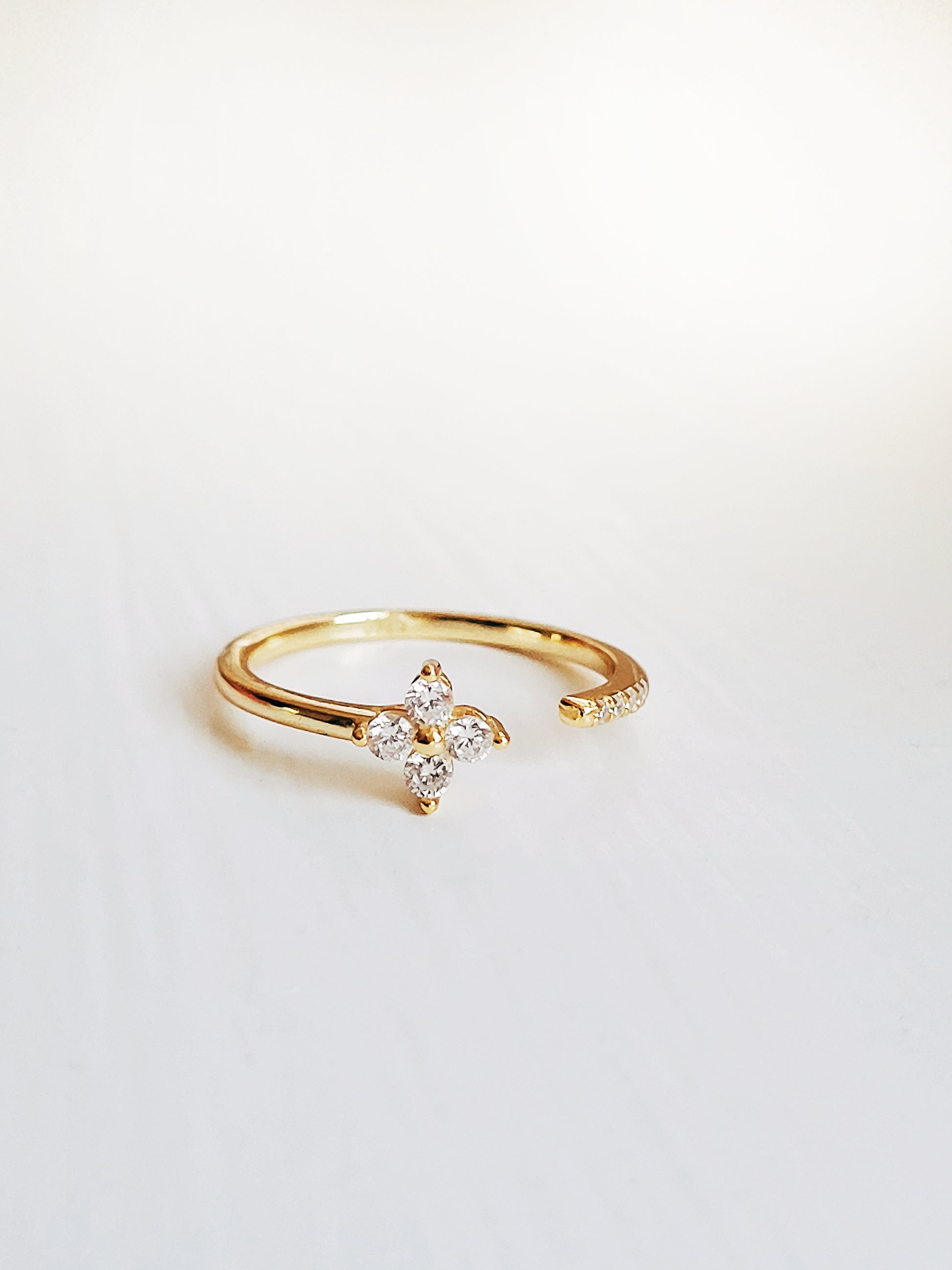 An exquisite gold-plated open clover ring adorned with a diamond flower, highlighting its delicate and stylish appeal.