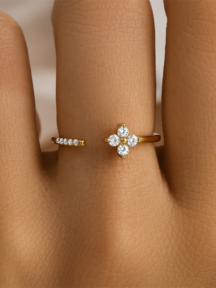 Close-up of a woman's hand showcasing a gold Clover ring featuring four brilliant diamonds.