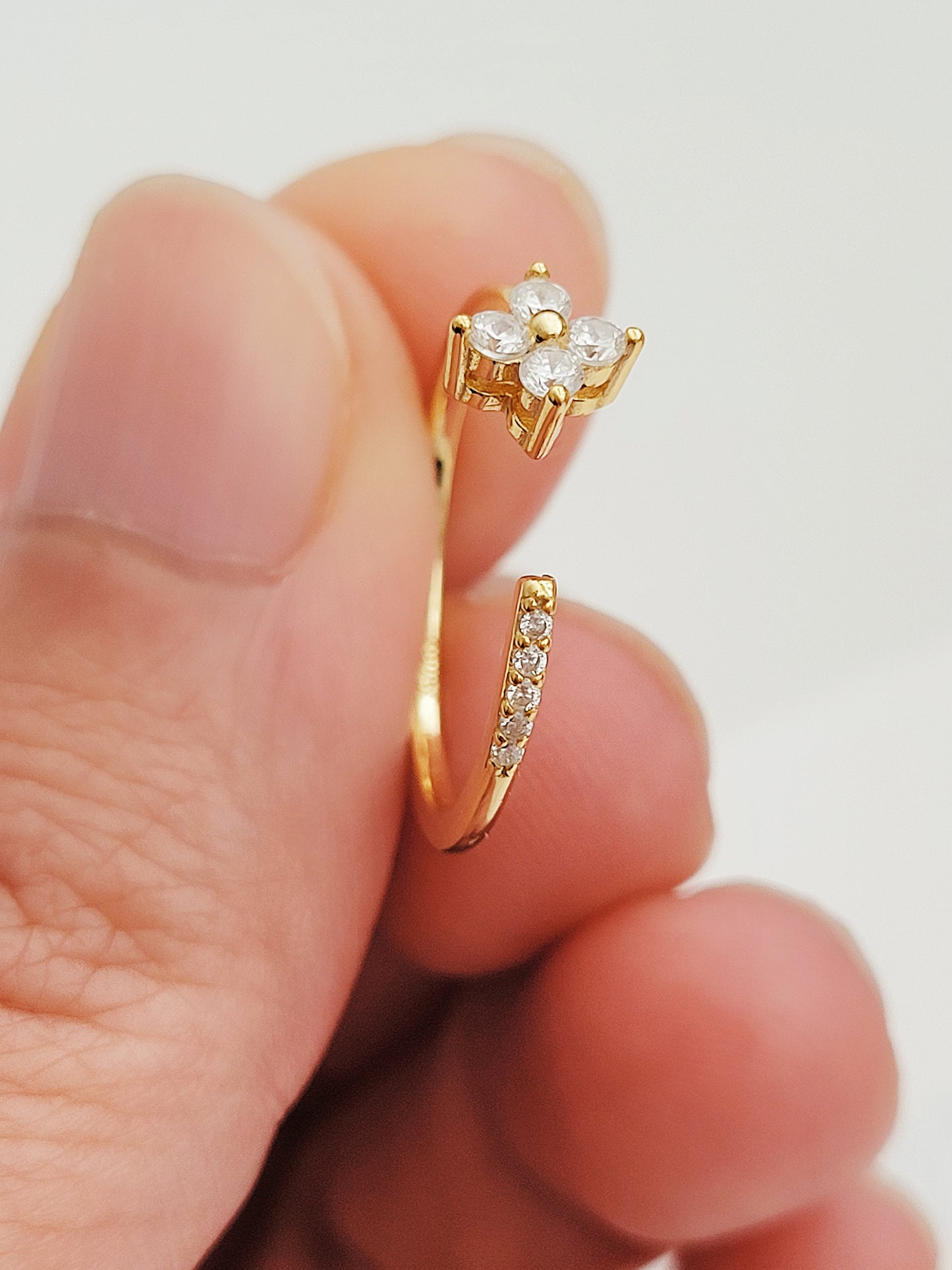 A stunning gold-plated open clover ring with a diamond flower centerpiece, exemplifying elegance and sophistication.