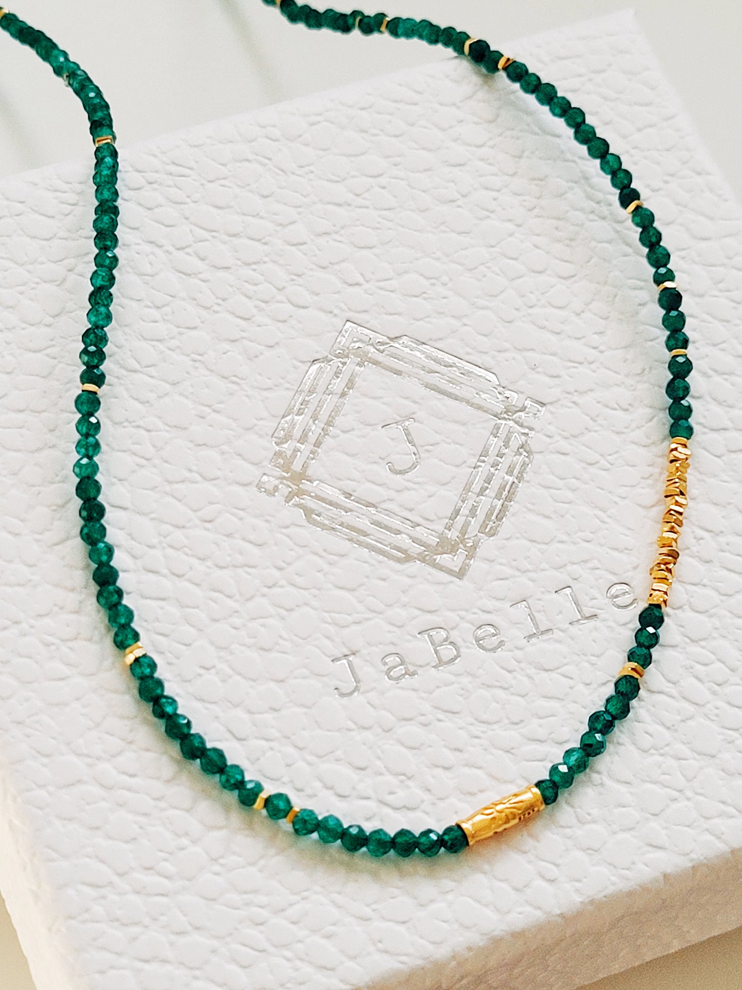 A close-up of a woman&#39;s neck wearing a Green Onyx Beaded Necklace with 18k Gold Vermeil beads, showcasing an elegant minimalist design perfect for everyday wear or special occasions.