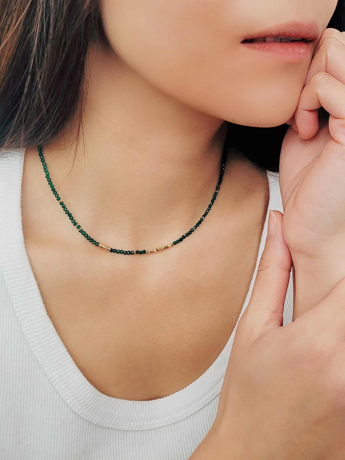 A close-up of a woman&#39;s neck wearing a Green Onyx Beaded Necklace with 18k Gold Vermeil beads, showcasing an elegant minimalist design perfect for everyday wear or special occasions.